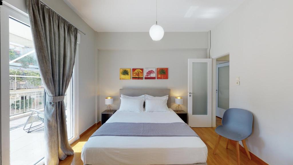 een slaapkamer met een bed en een groot raam bij Penthouse of light @ Koukaki in Athene