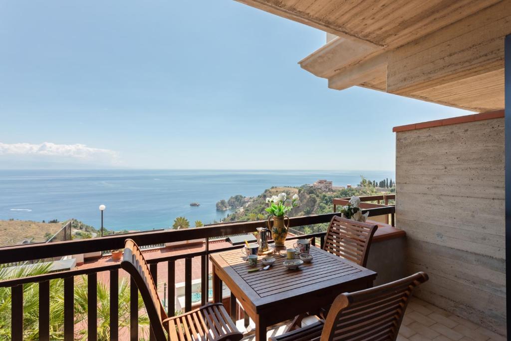 einen Tisch auf einem Balkon mit Meerblick in der Unterkunft Taormina Panoramic Seaview Apartment in Taormina
