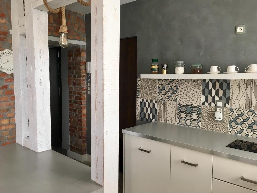 a kitchen with a counter and a brick wall at kameralny apartament II in Olsztyn