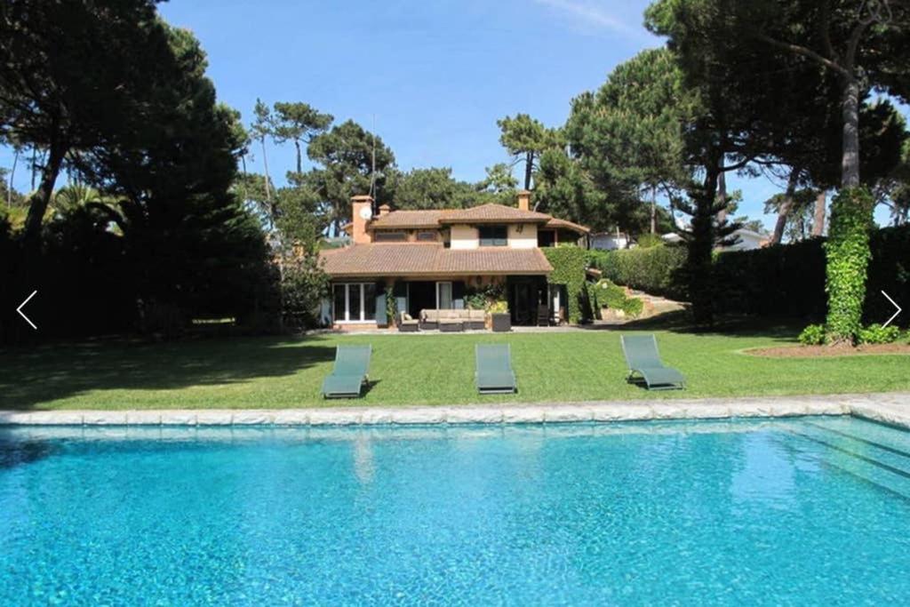a house with a swimming pool with two lounge chairs at Family Dream in Colares