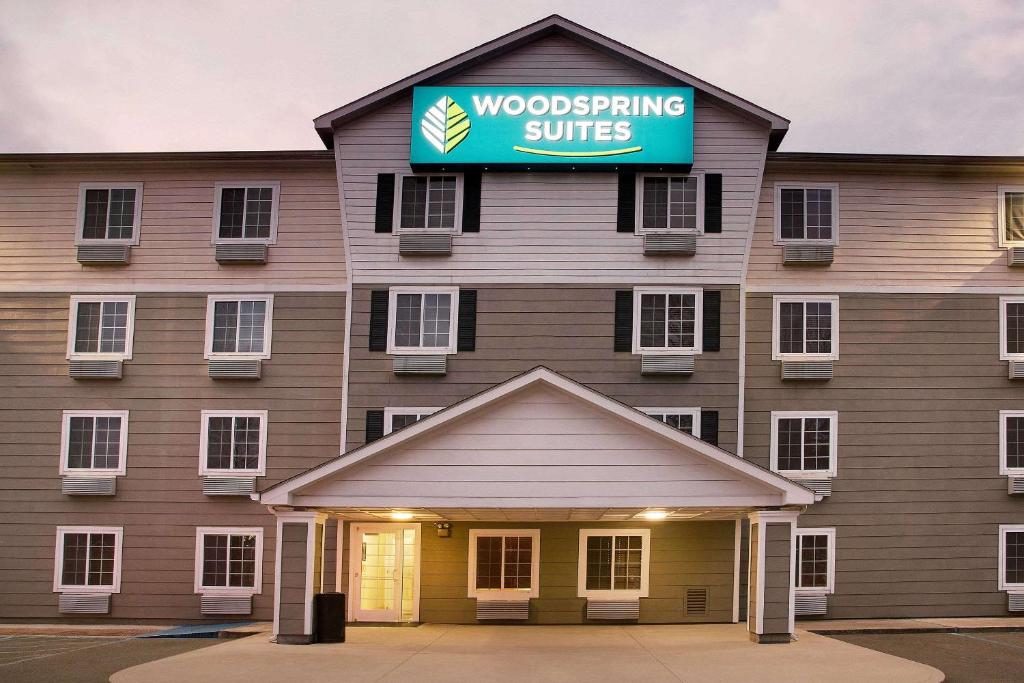 a building with a woodworking suite sign on it at WoodSpring Suites Baton Rouge Airline Highway in Baton Rouge