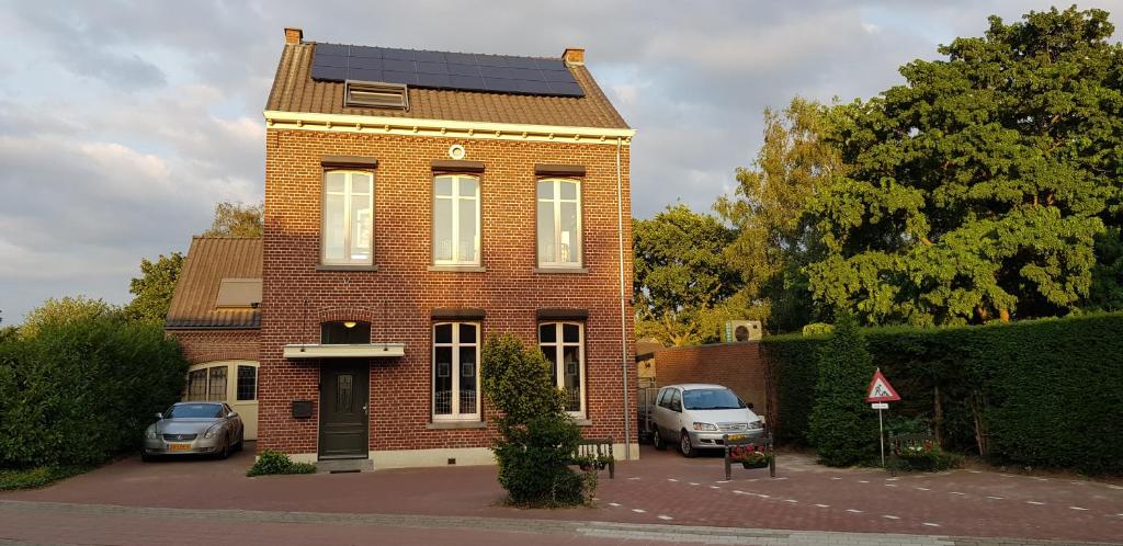 een rood bakstenen huis met een zonnedak bij ANNO 1919 in Swalmen