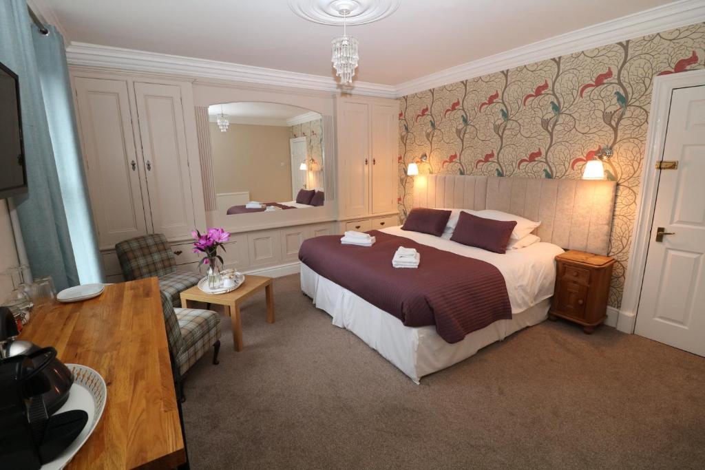 um quarto de hotel com uma cama e um espelho em Four Seasons Guesthouse em Castleton