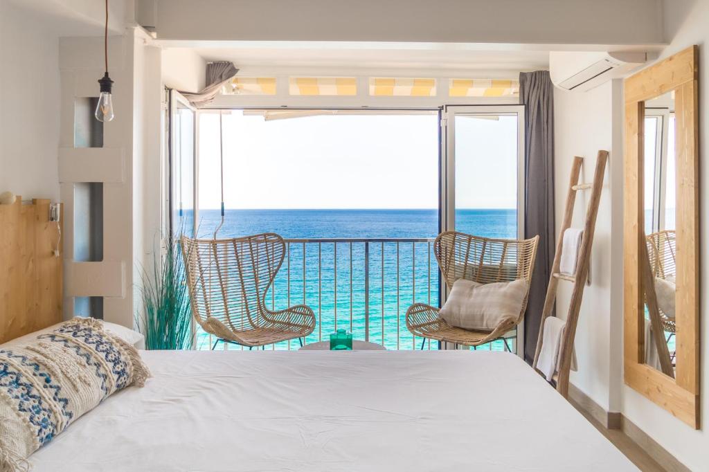 プラヤ・デアロにあるSugar Beach Boutique Studioのベッドルーム1室(ベッド1台付)、海を望むバルコニーが備わります。