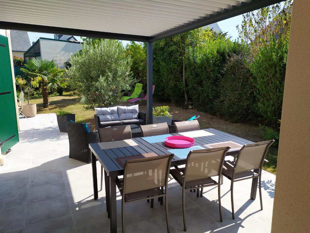 eine Terrasse mit einem Tisch, Stühlen und einem Sofa in der Unterkunft grande chambre lumineuse et spacieuse 22m2 in Guérande