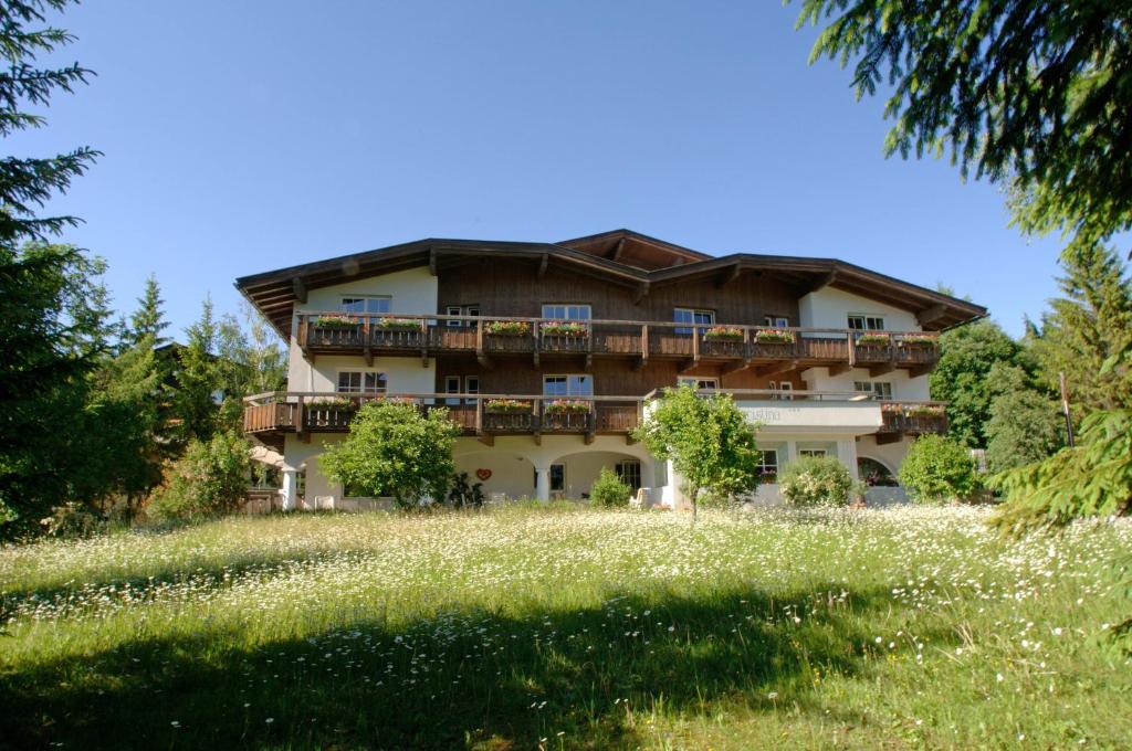 a house on a hill with a field of flowers at Hotel Christina in Seefeld in Tirol