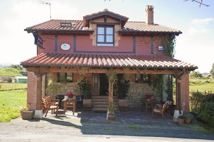 una casa con un cenador frente a ella en Posada los Taranos, en Valdáliga