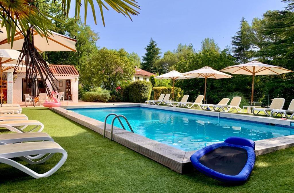 einen Pool mit Stühlen und einem Floß im Hof in der Unterkunft Résidence Miro in Les Arcs sur Argens