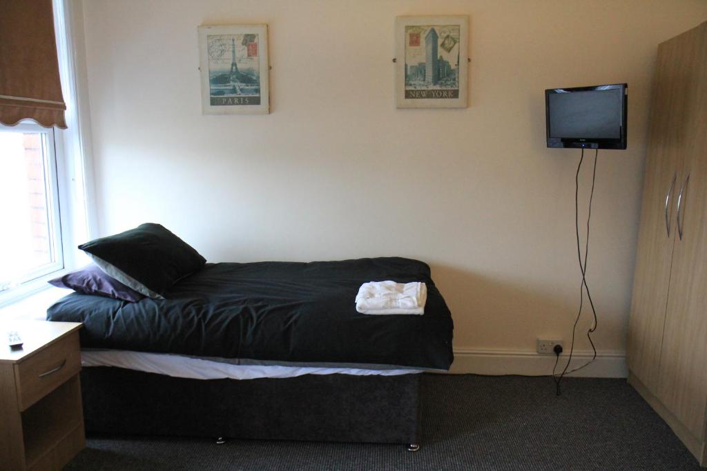 um quarto com uma cama e uma televisão na parede em Clifton arms em Liverpool