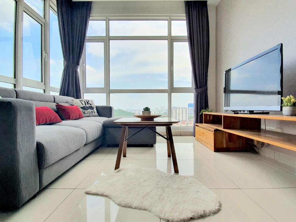 ein Wohnzimmer mit einem Sofa und einem TV in der Unterkunft Kuala Lumpur Central Residences by BeeStay Management in Kuala Lumpur