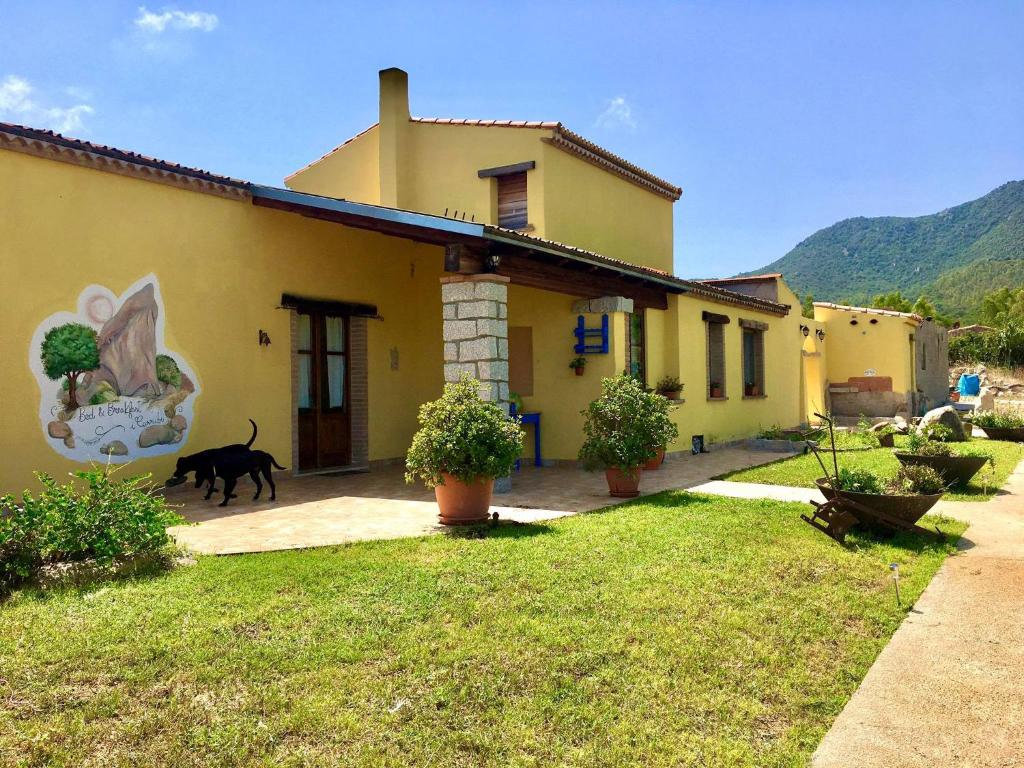 a black dog walking in front of a house at I Carrubi in San Priamo