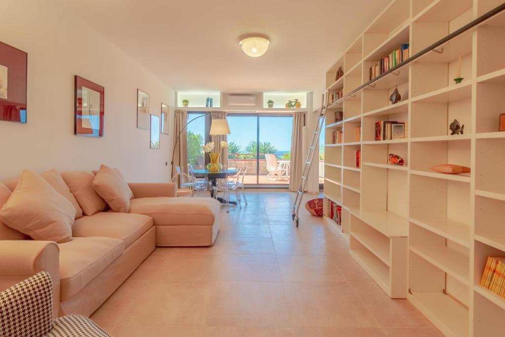 een woonkamer met een bank en boekenplanken bij CASA CAROLINA Mare, Comfort e Relax in Camogli