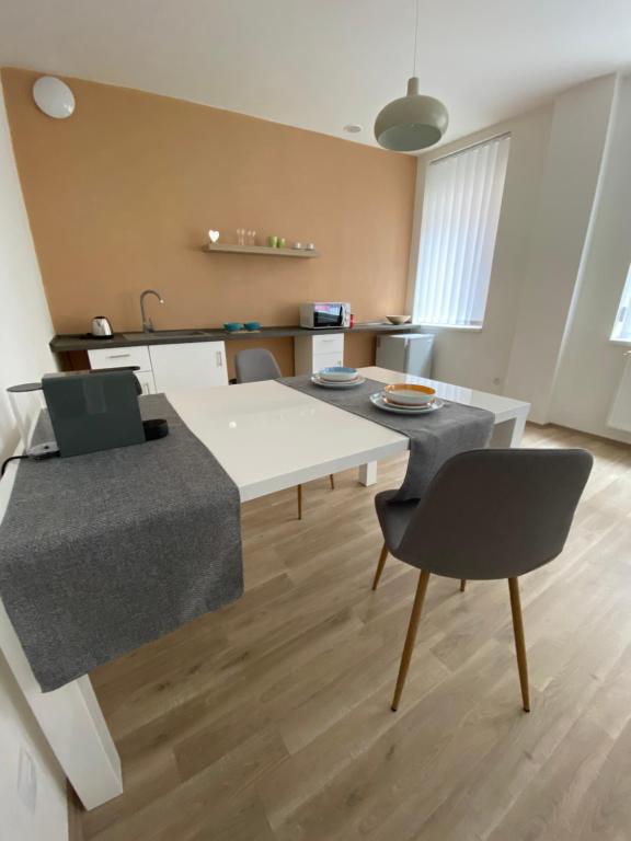 ein Wohnzimmer mit einem weißen Tisch und Stühlen in der Unterkunft Apartmán OKO in Písek