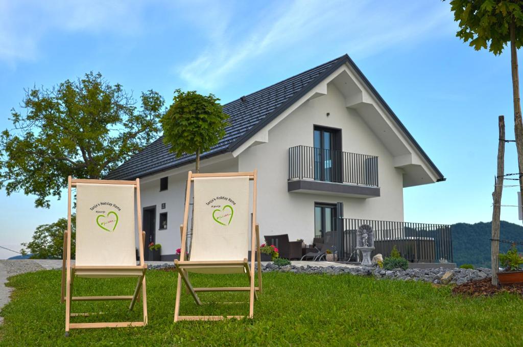 two folding chairs in front of a house at Tanja s Holiday Home in Nature with sauna and hot tub in Gorica pri Slivnici