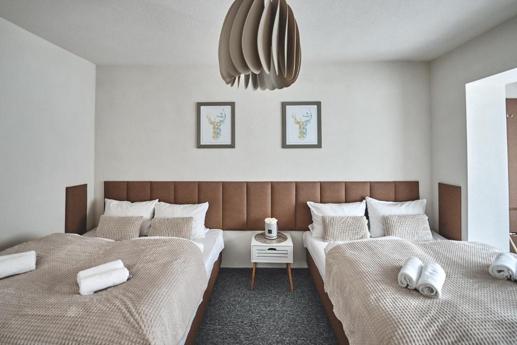 a bedroom with two beds and a pendant at Apart Nova - pokoje gościnne in Szczyrk