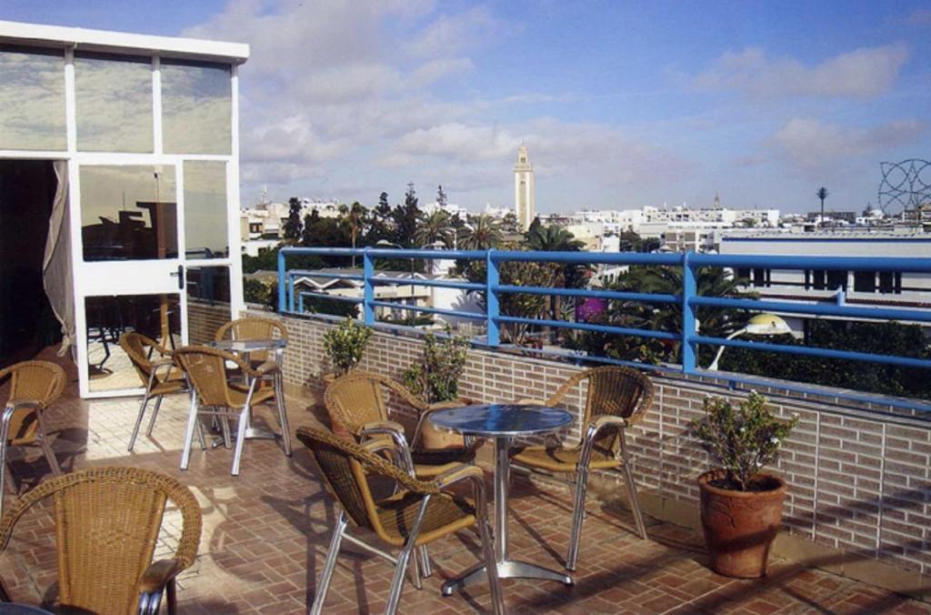 a patio with chairs and tables on a balcony at Hôtel Petite Suède in Agadir