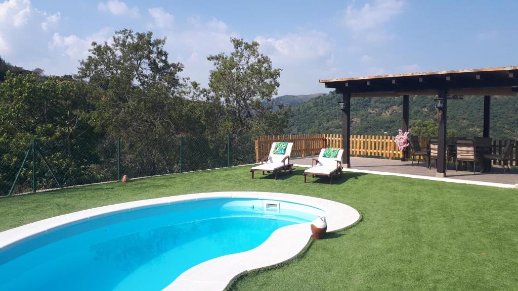 un patio trasero con piscina y cenador en Villa Evelyn, en Gaucín