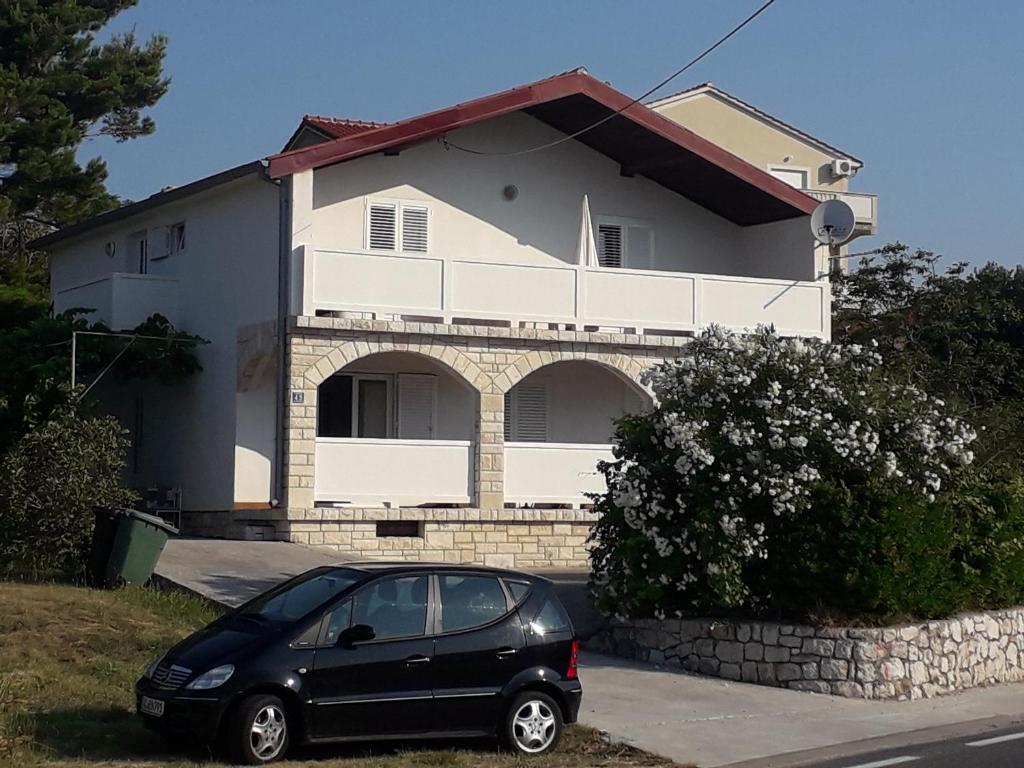 a black car parked in front of a house at Apartments Babić in Rab