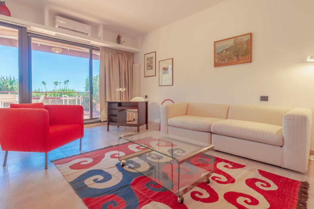 a living room with a couch and a red chair at CASA CARLOTTA Tranquillità con Vista Mare in Camogli