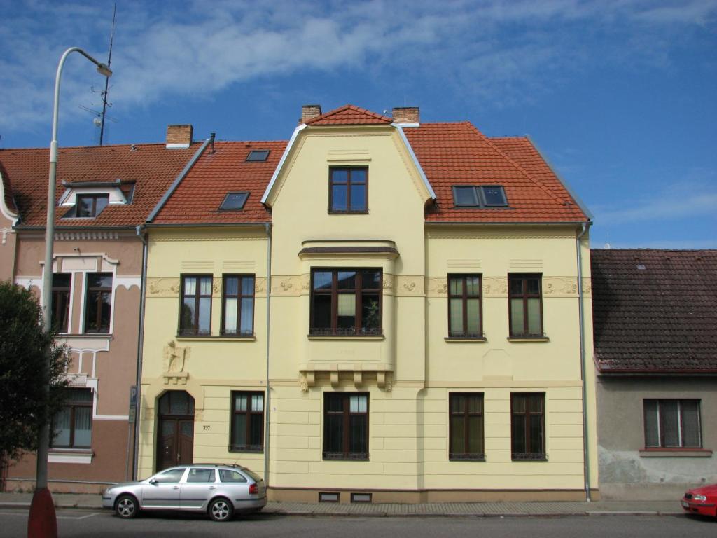 ein gelbes Haus mit einem davor geparkt in der Unterkunft Vila Vanilka in Bechyně