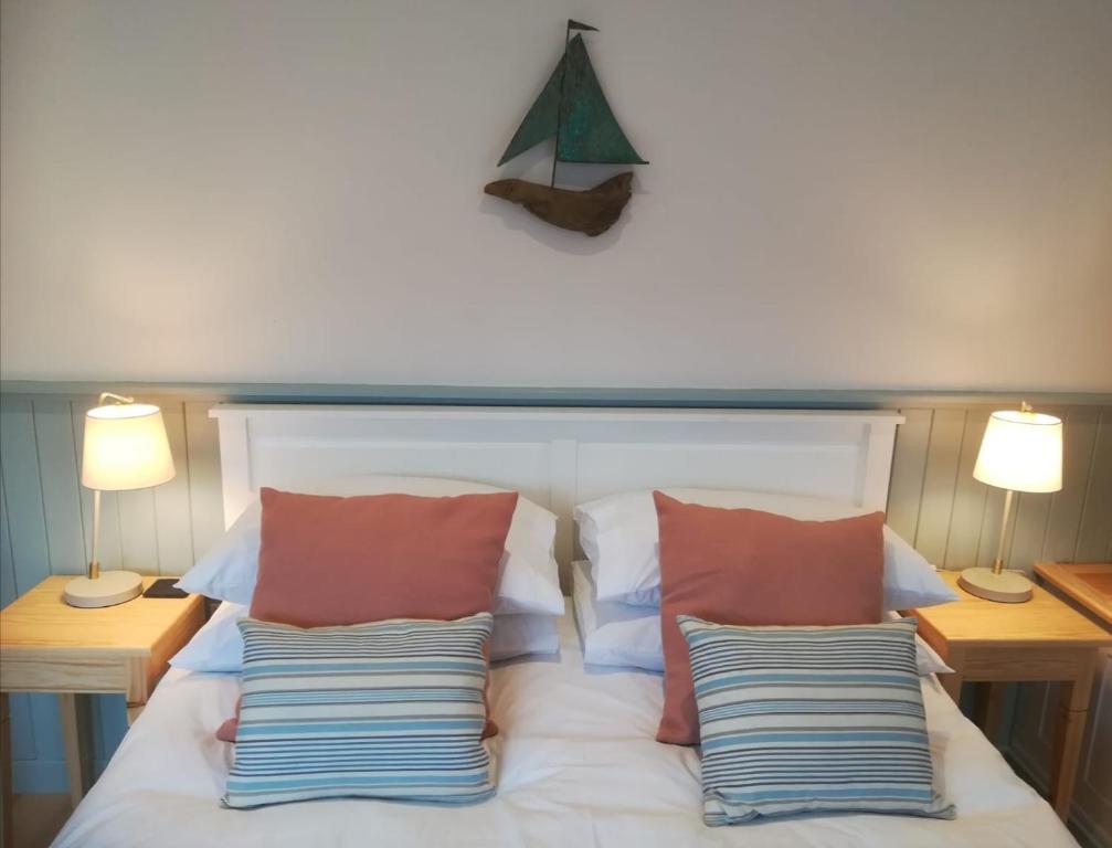 1 dormitorio con 1 cama con almohadas y 2 lámparas en Sea Breeze en Freshwater
