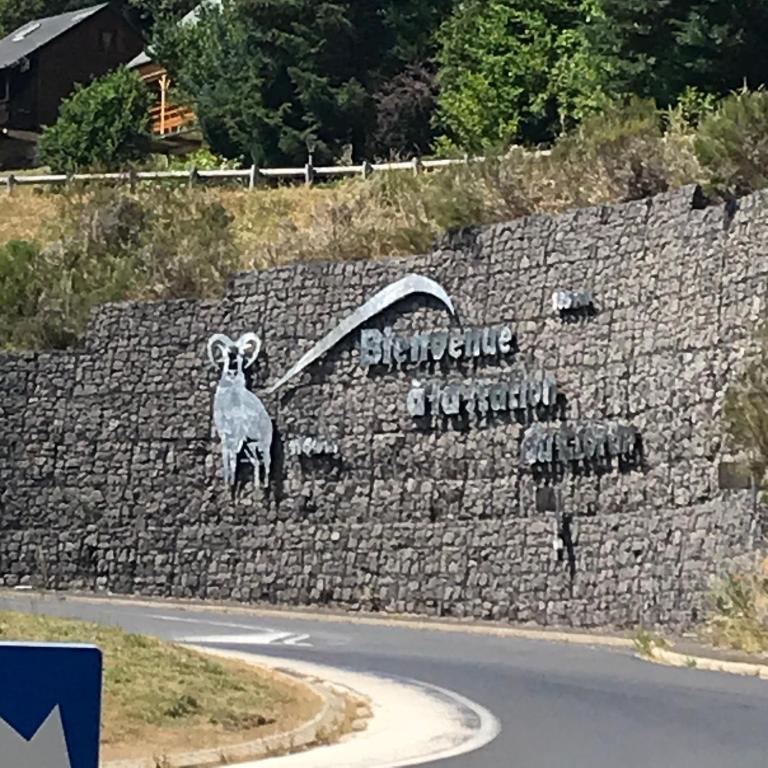 une fresque d'un mouton sur un mur de pierre dans l'établissement Appartement au pied des pistes, à Le Lioran