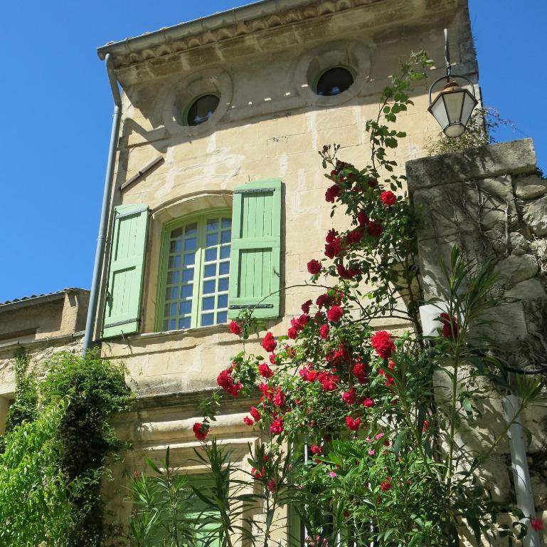 ein Gebäude mit einem Fenster mit roten Blumen darauf in der Unterkunft La Buissonnière in Oppède