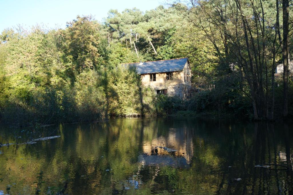 una casa vieja sentada al lado de un río en Le triskel de Bertaud, en Bain-de-Bretagne