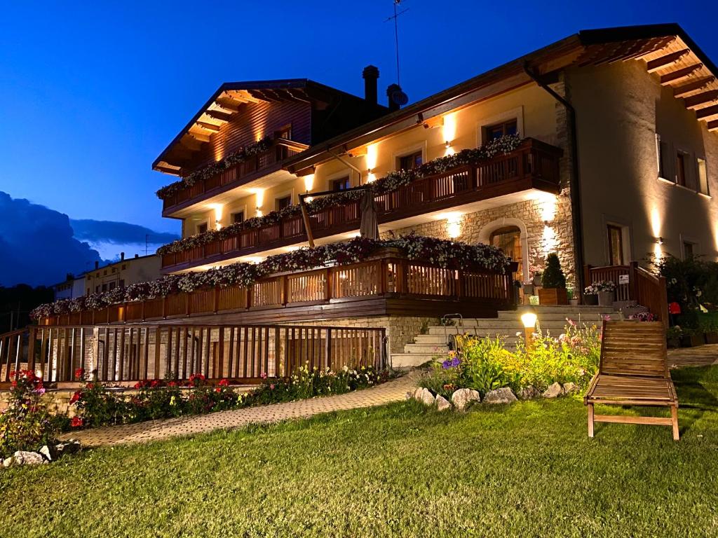 a large building with a porch and a bench in the yard at Boutique Hotel Il Riccio - Adults Only in Roccaraso