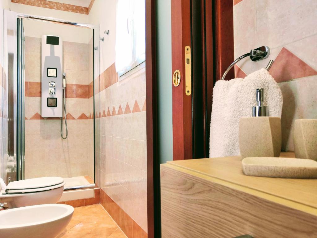 a bathroom with a toilet and a sink and a shower at Casa vacanze Acero rosso in Massa Martana