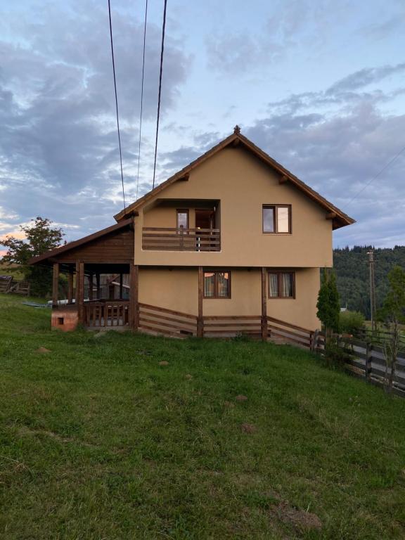 a house sitting on top of a green field at Cabana Vlad 1 in Piatra Fantanele