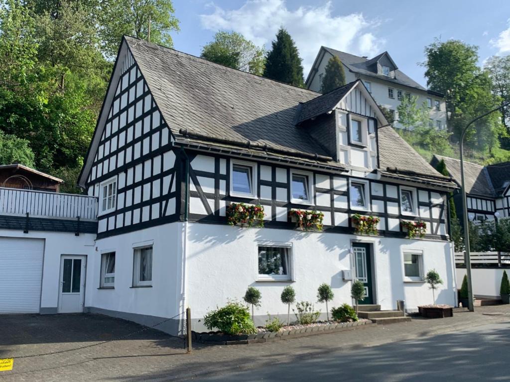 a black and white building with flowers in the window at Ferienhaus Sauerland-Träume in Schmallenberg
