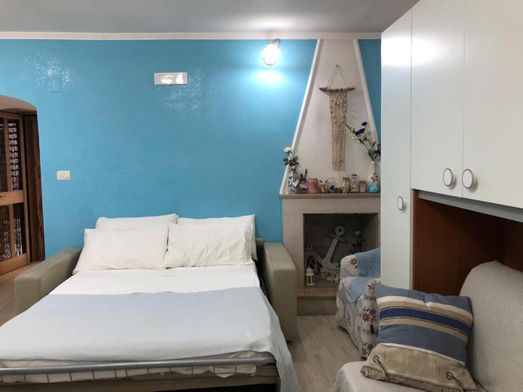 ein blaues Zimmer mit einem Bett und einem Sofa in der Unterkunft Cottage Azzurra in Ischitella