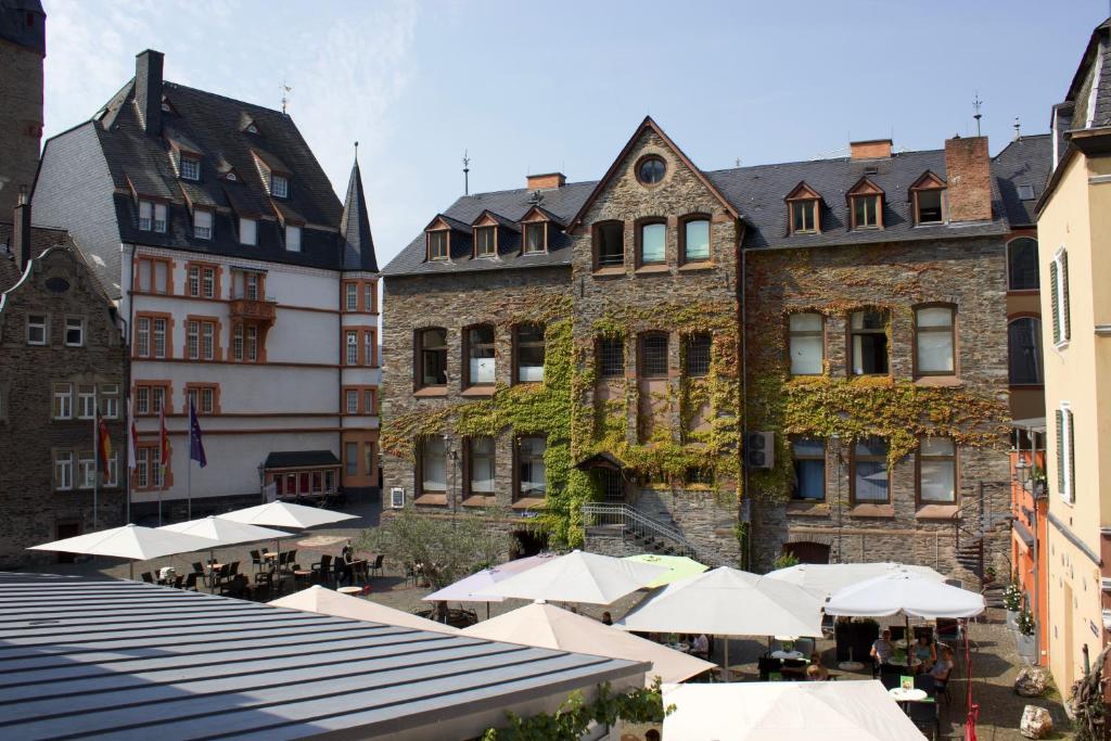 eine Gruppe von Gebäuden mit Tischen und Sonnenschirmen in der Unterkunft Ferienwohnung Bloom in Bernkastel-Kues