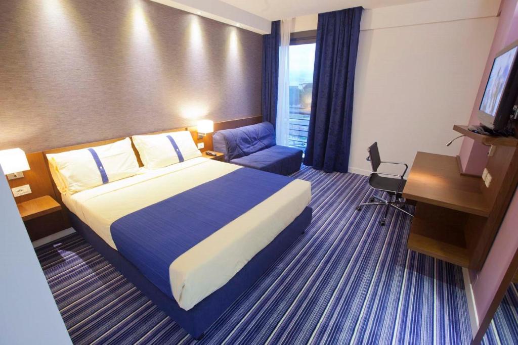 una camera d'albergo con letto, scrivania e TV di GP Hotel a Roma