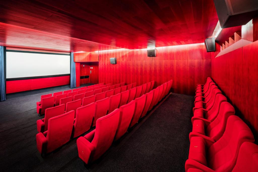 a red room with red chairs in a theatre at Hotel Thermal in Karlovy Vary