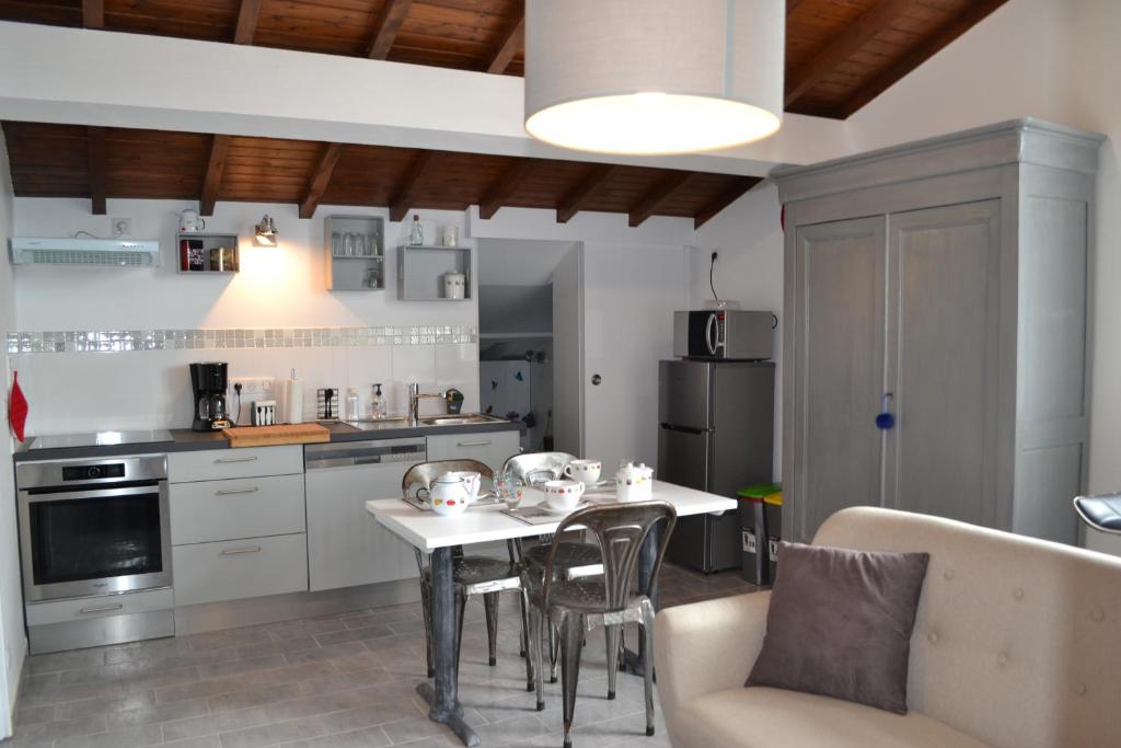 a kitchen with a table and chairs in a room at LE POINT DU JOUR in Bon-Encontre