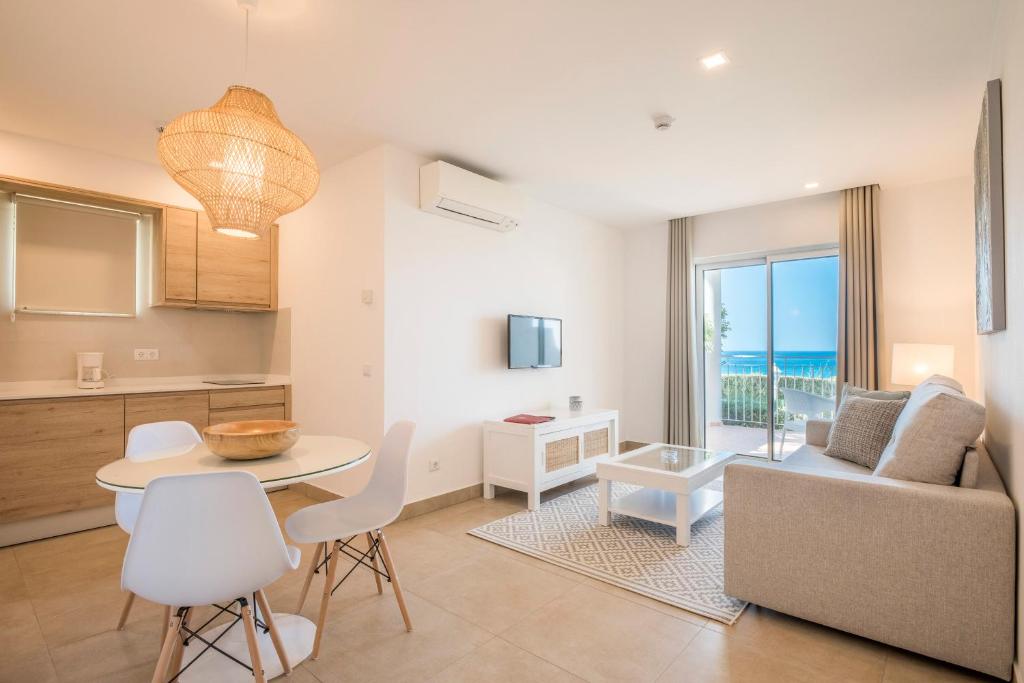 a kitchen and living room with a table and a couch at Clube Porto Mos - Sunplace Hotels & Beach Resort in Lagos