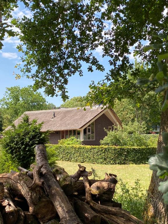 a log in front of a house with a house at Het Beregoed in Malden