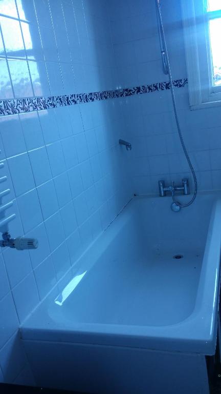 een wit bad in een badkamer met een blauw licht bij Blackburn - Great prices, best rooms, nice place ! in Blackburn