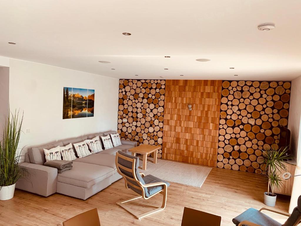 ein Wohnzimmer mit einem Sofa und einer Holzwand in der Unterkunft Ferienwohnung Bad Camberg - Apartment 3 Hoelzer in Bad Camberg
