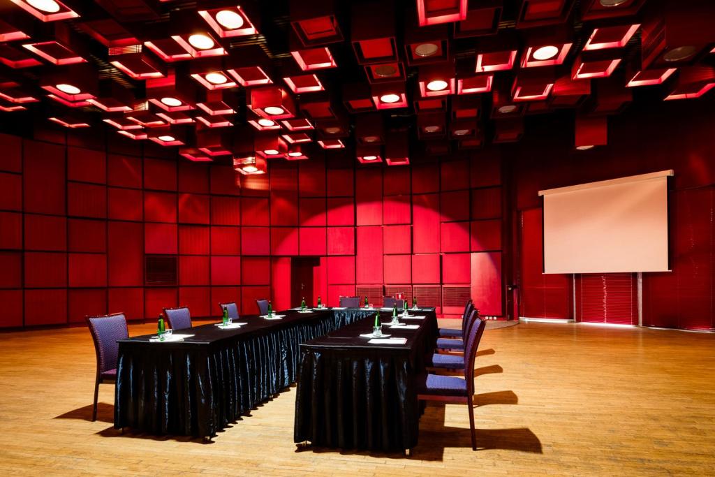 a conference room with tables and chairs and red walls at Hotel Thermal in Karlovy Vary