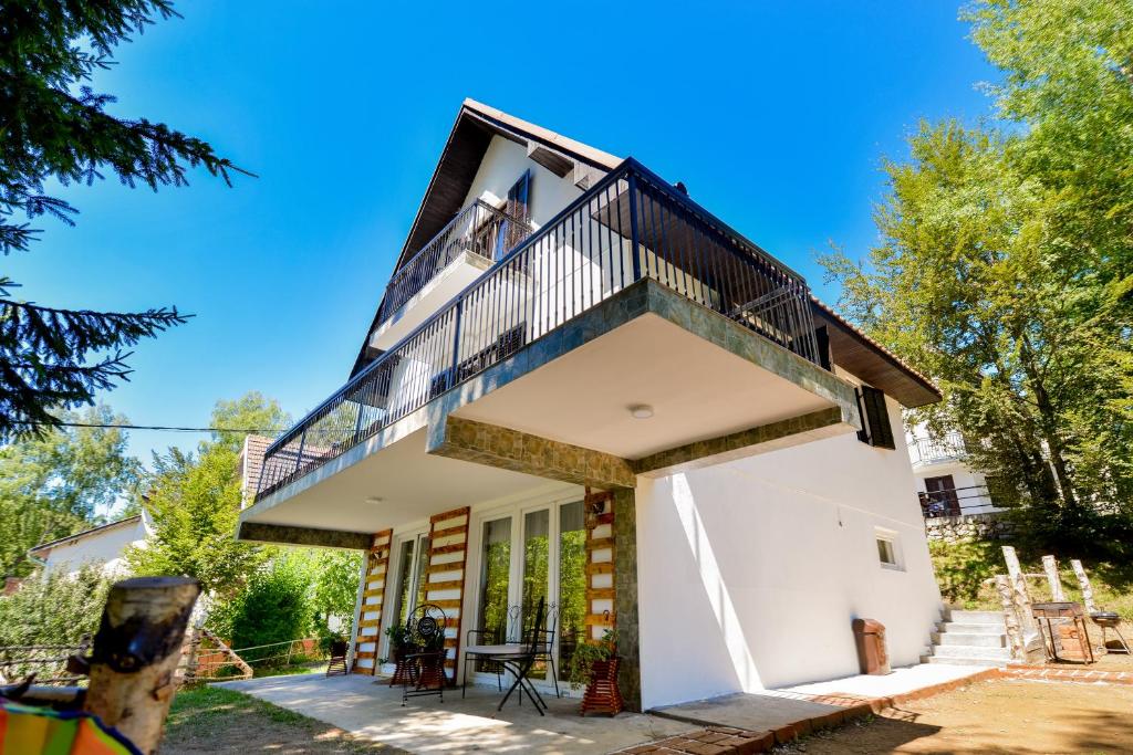 a house with a balcony on top at Apartmani Sunčev breg Vlasinsko jezero in Surdulica