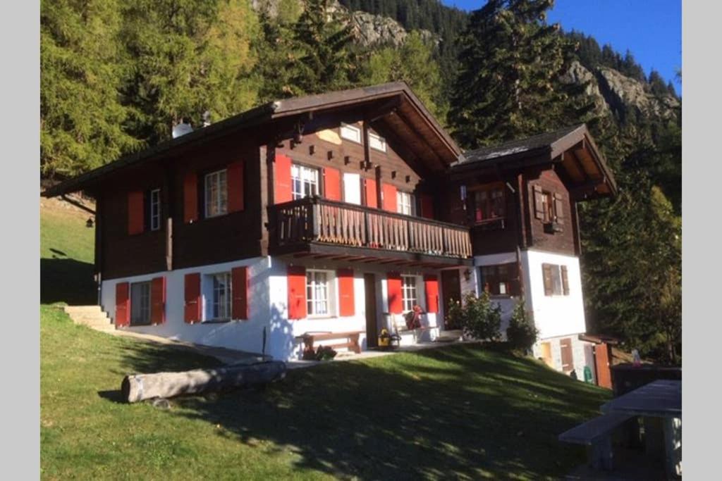 uma casa grande com uma varanda num campo de relva em Idyllisches Chalet inmitten der Walliser Bergwelt em Riederalp