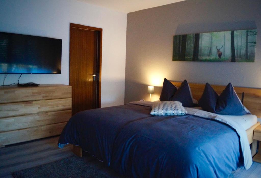 Schlafzimmer mit einem blauen Bett und einem Flachbild-TV in der Unterkunft Schwarzwald geht immer Fewo 60 qm mit großem Südbalkon, WLAN und Magenta TV in Schönwald