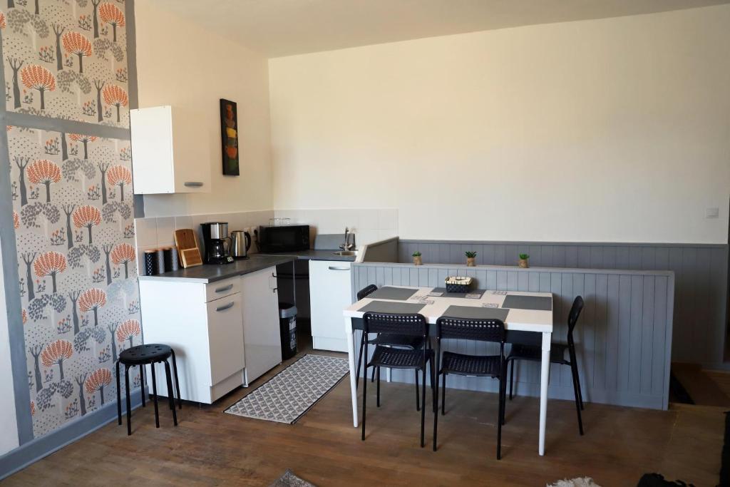 uma cozinha com mesa e cadeiras num quarto em L'appartement 62 em Le Lonzac
