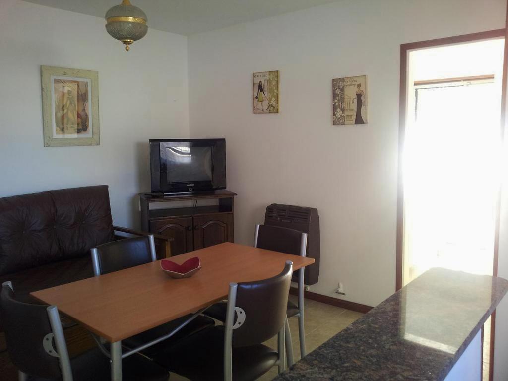 sala de estar con mesa de madera y TV en Apartamento Miramar Calle 21 en Miramar