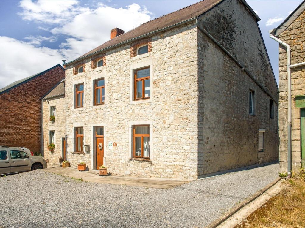 ein Steingebäude mit einem davor geparkt in der Unterkunft Plush Holiday Home in Matagne La Petite with Private Garden in Matagne-la-Petite