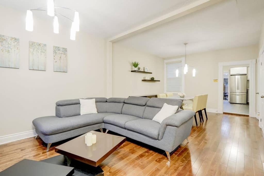 uma sala de estar com um sofá cinzento e uma mesa em JstLikeHome - Central Suite em Ottawa