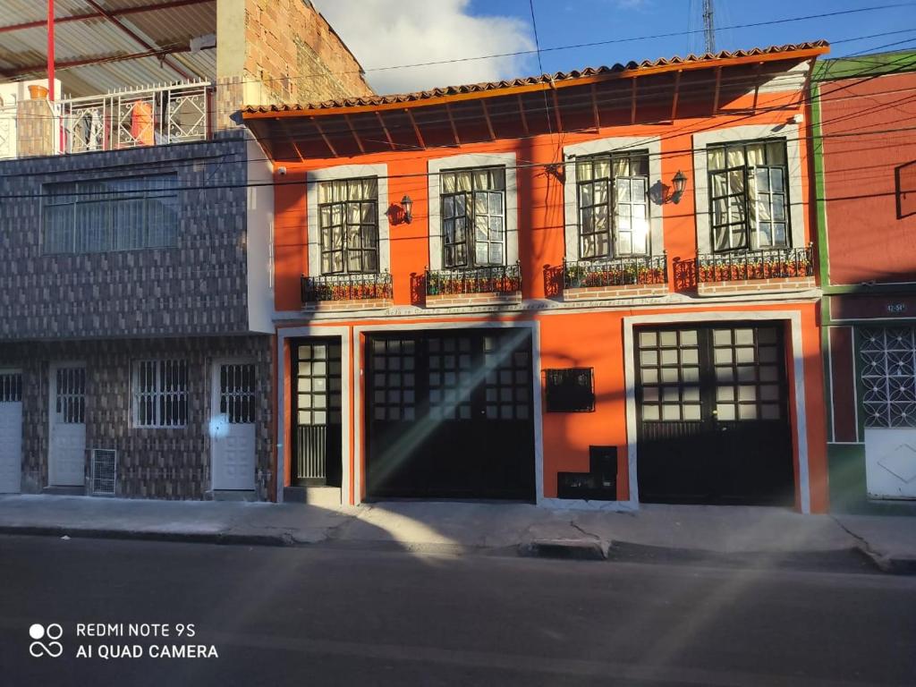 um edifício laranja com portas e janelas pretas em Hogar COLONIAL em Bogotá